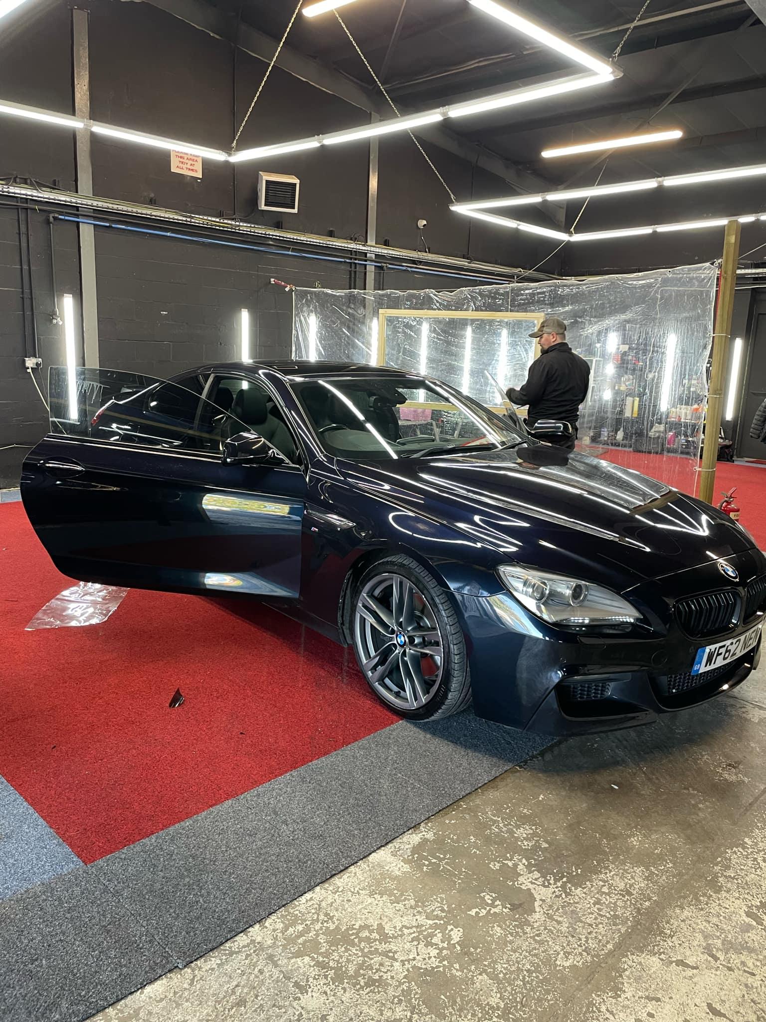 Dark BMW 6 Series on the red carpet in the detailing bay
