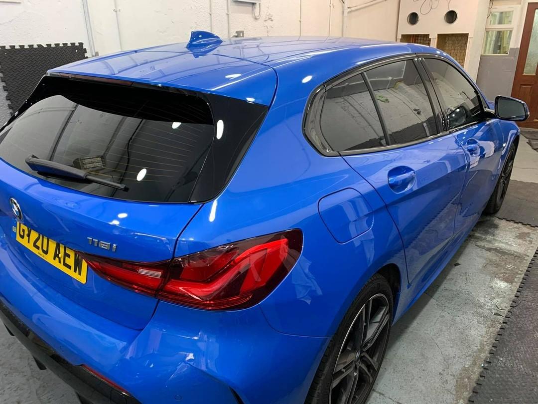 Blue BMW 1 Series from the rear with tinted rear windows