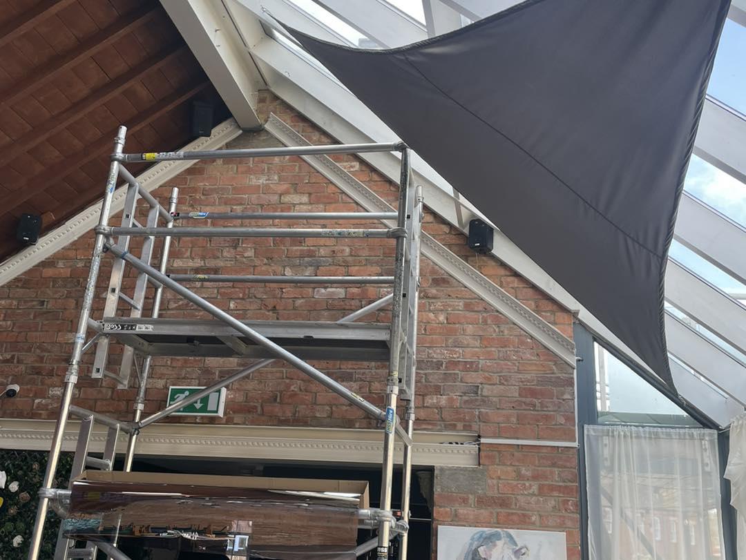 Glass roof being tinted from scaffolding inside a commercial building