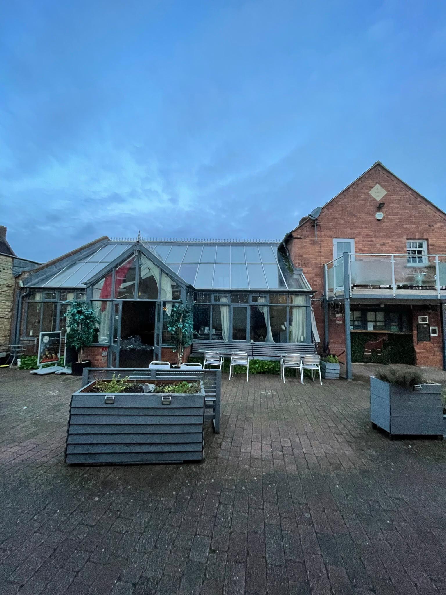 Restaurant with a large glass conservatory facing a courtyard