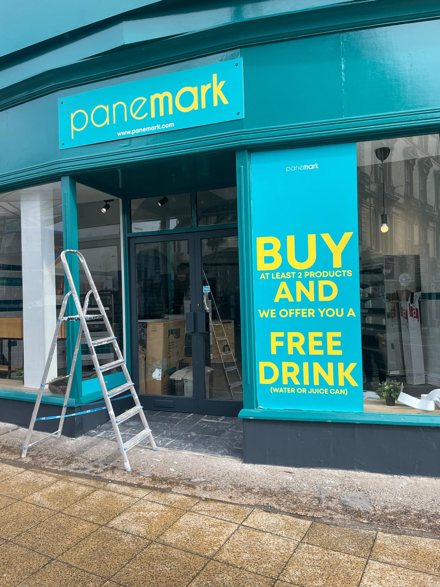 Shop front with a stepladder outside during a window film fit