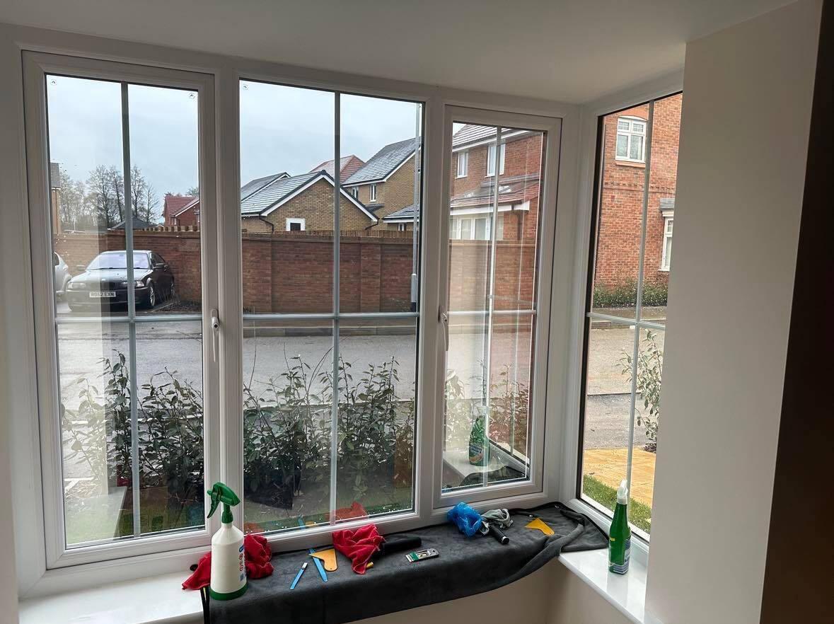 Bay window in a home with tinting tools laid out on the sill