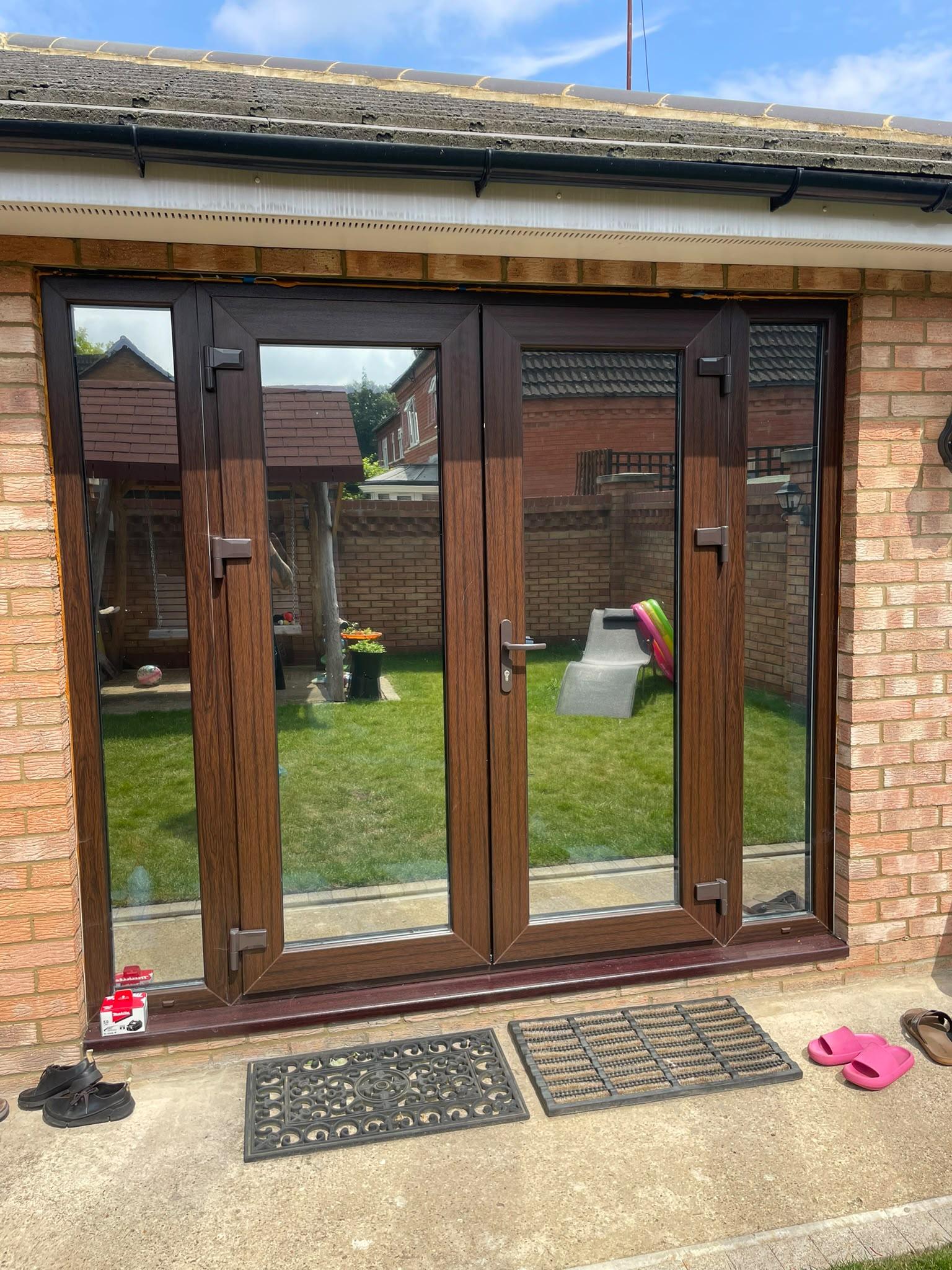 The same French doors after reflective film: the glass shows the garden, not the room inside