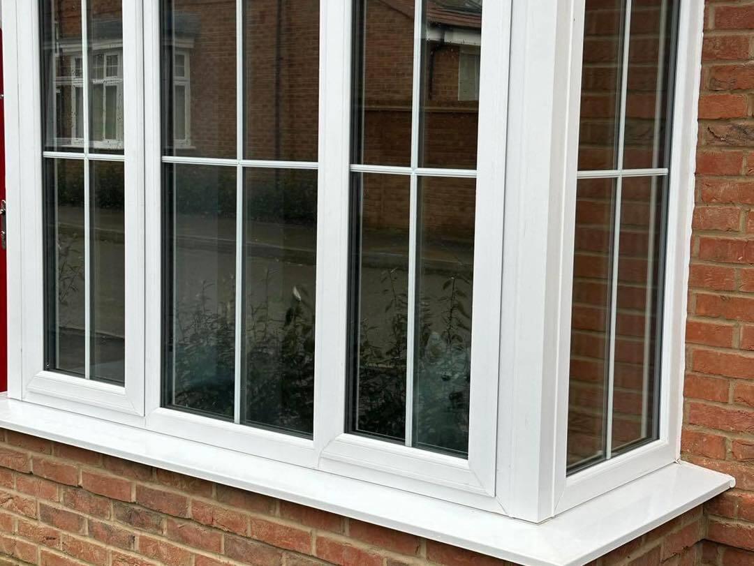 White uPVC windows on a brick house, seen from outside